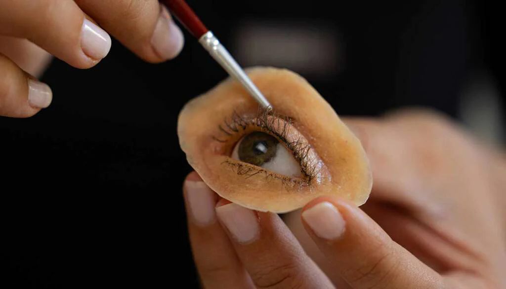 A person holding an apple core with an eye on it.