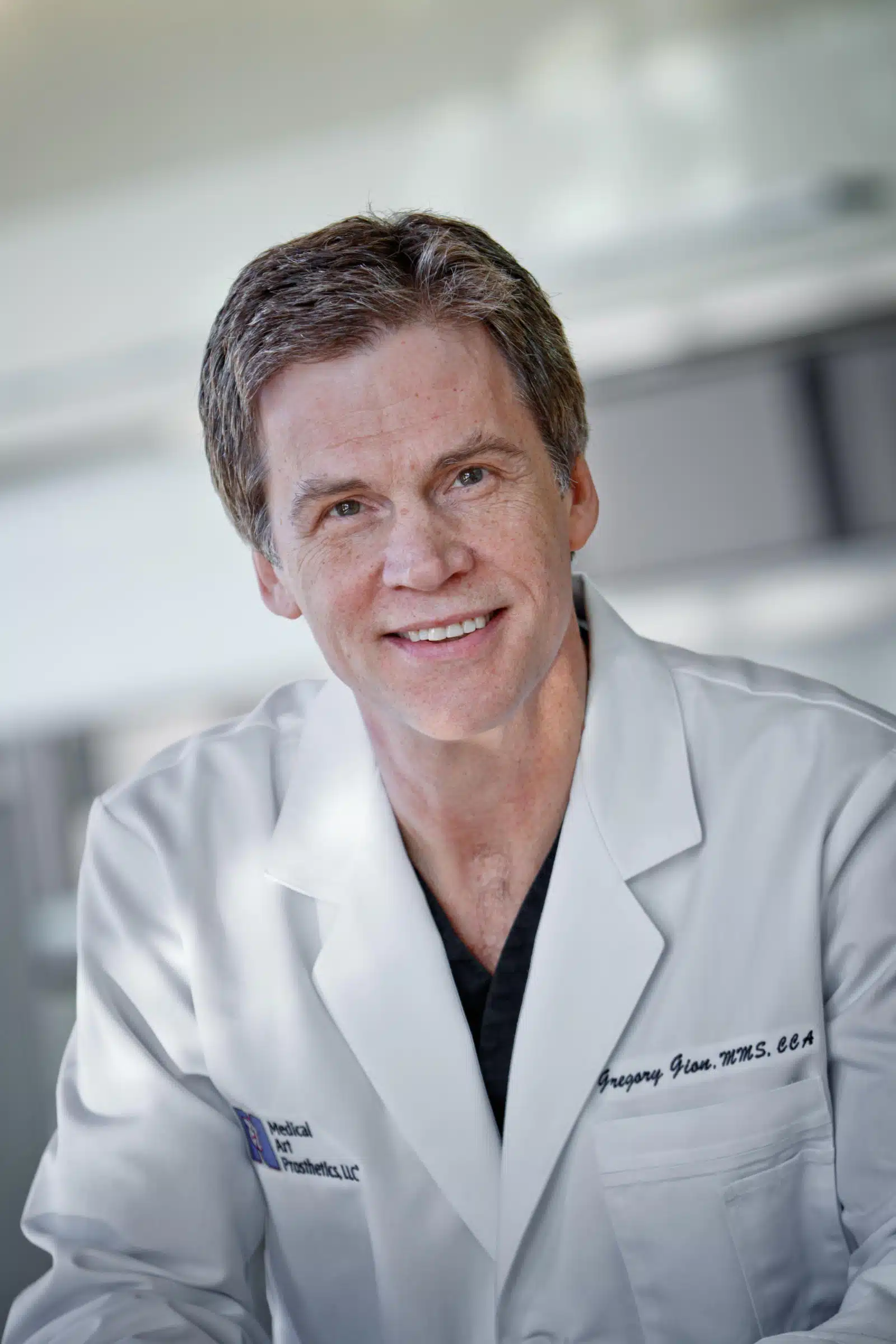 A man in white lab coat smiling for the camera.