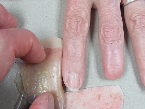 A person is peeling off the finger nail.