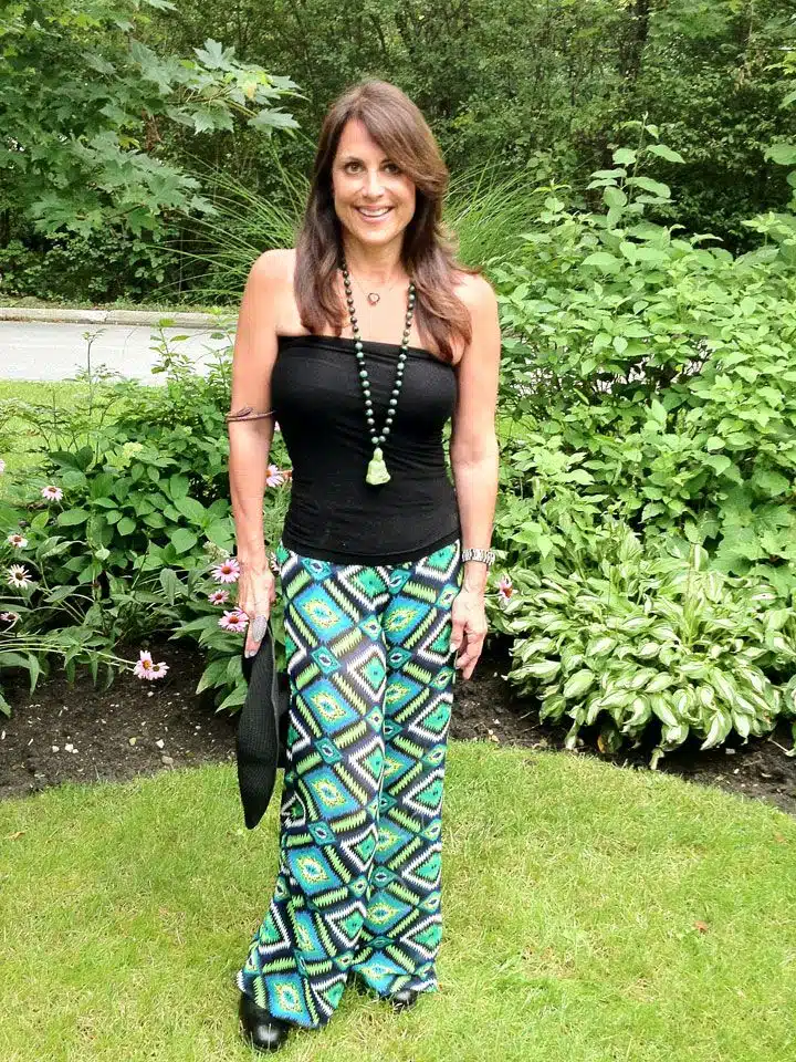 A woman standing in the grass wearing a black top.