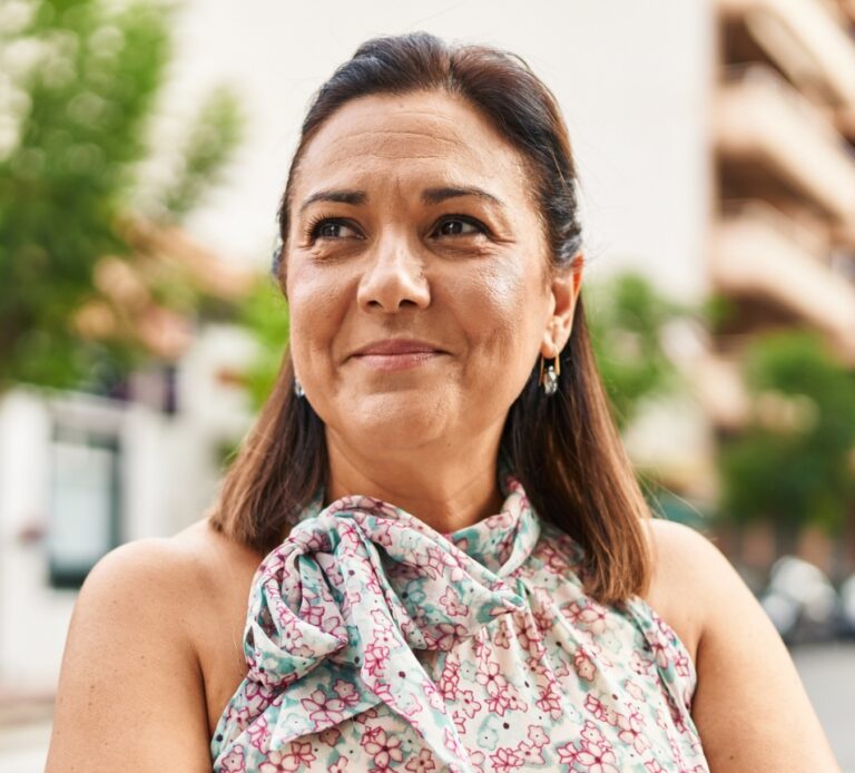 a woman smiling with a floral shirt