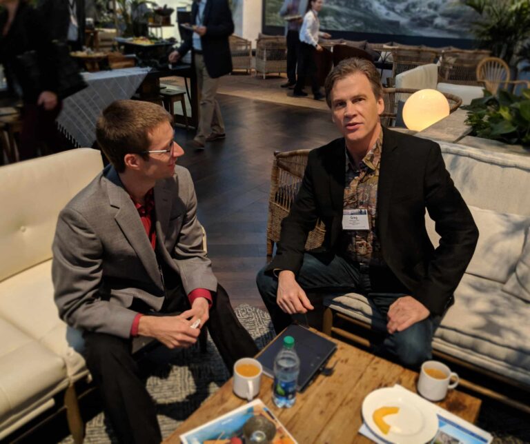 two men sitting in chairs and talking