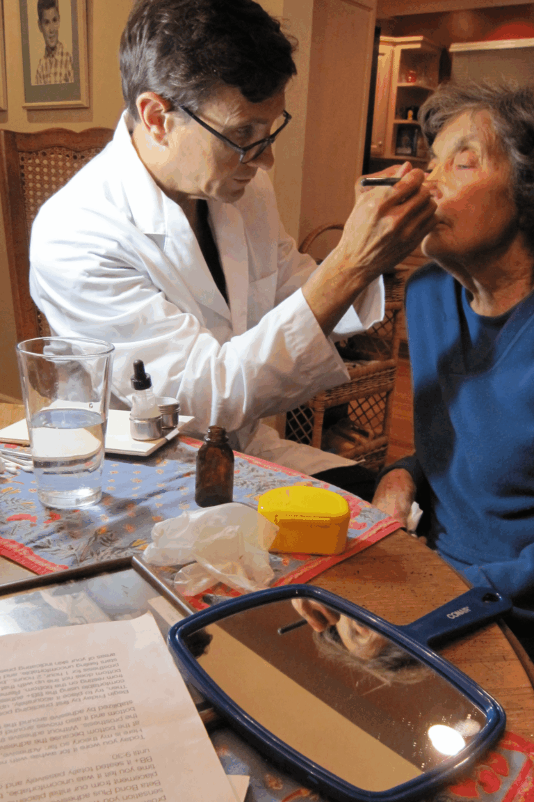 a man putting makeup on a woman's face
