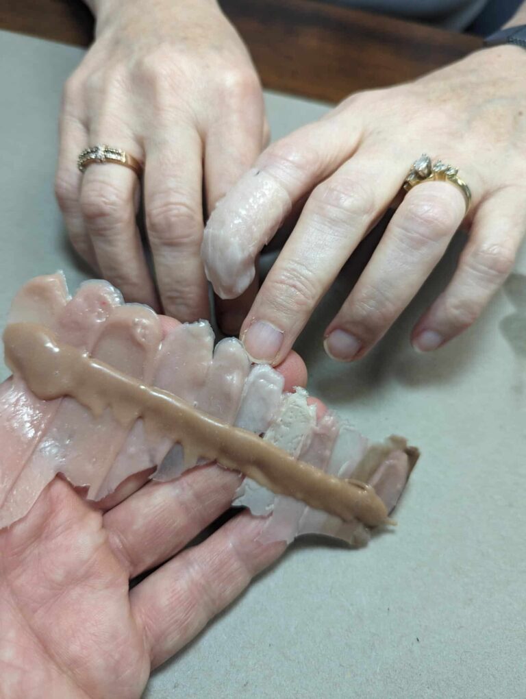 a person's hands with a fake jaw