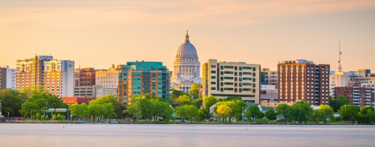 a city with a domed building and trees by a body of water