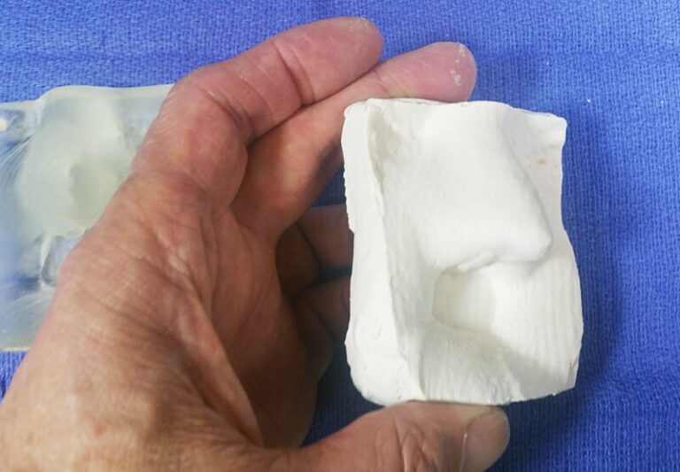 a hand holding a white object