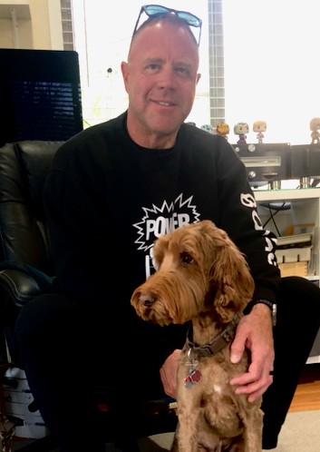 photo of man with new prosthetic ear enjoying clinic therapy dog